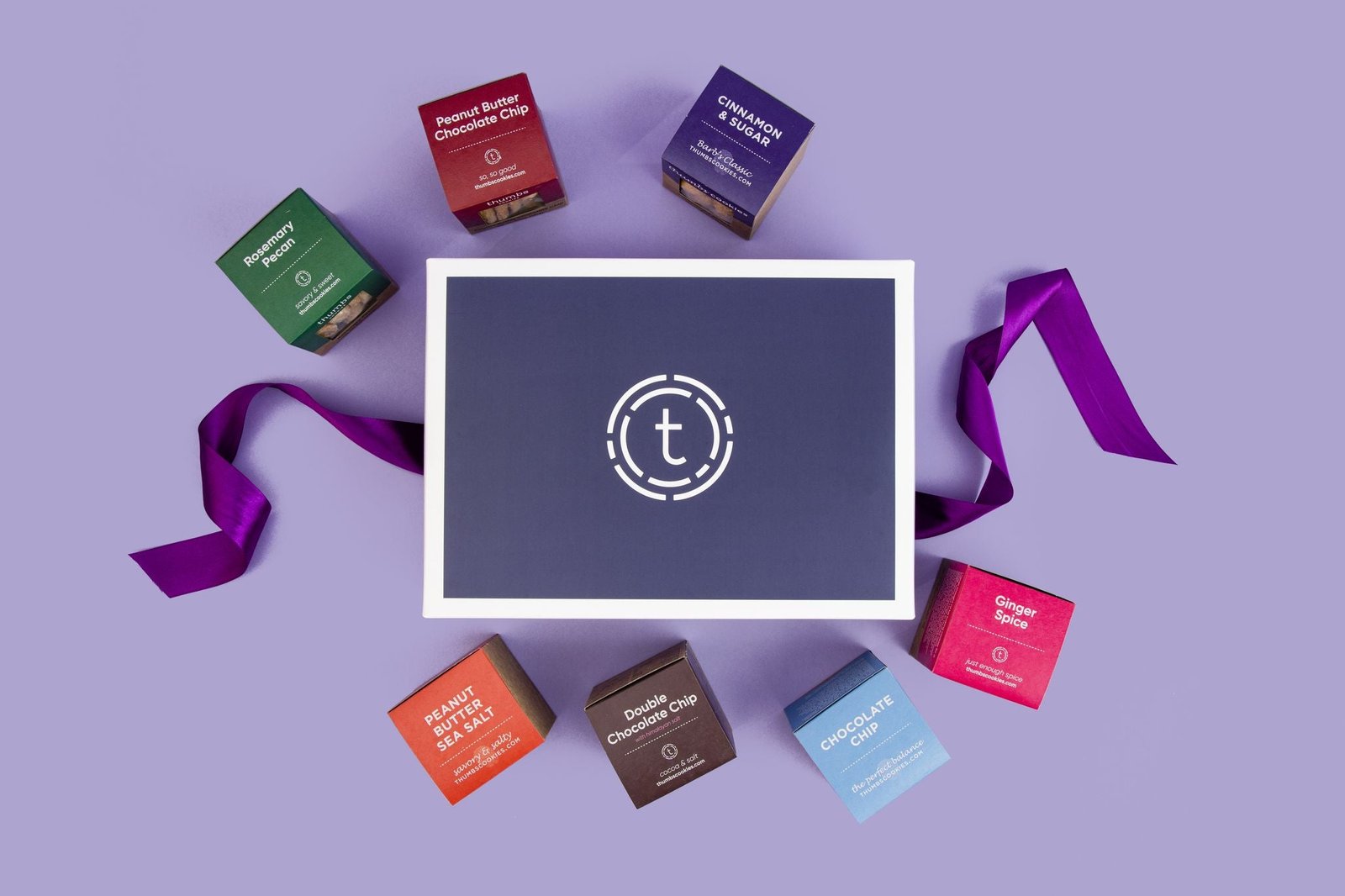 Elegant gift box with six shortbread cookie cubes in beautiful packaging, tied with a satin purple ribbon.